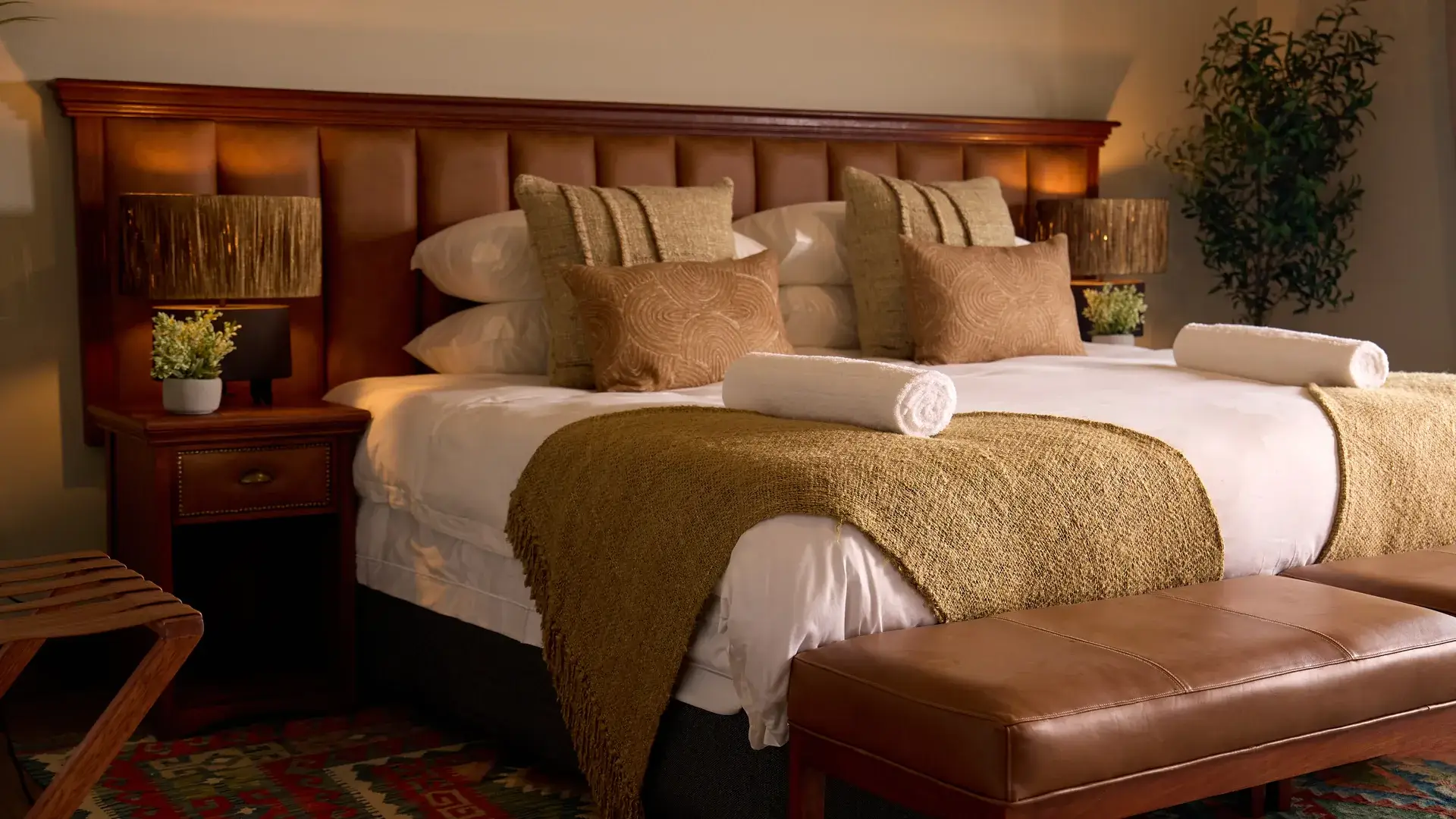 King bed with leather benches in an Impala tent